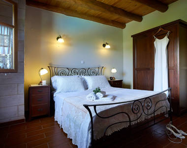 Vederi Estate Villa Alkioni bedroom with decorated double bed with bedside tables and wardrobe