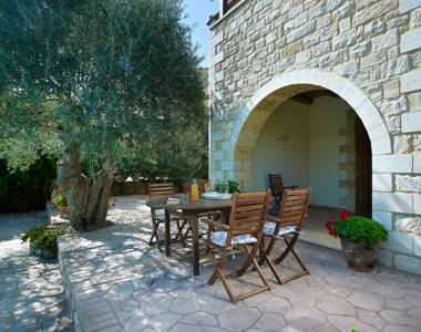 Vederi Estate Villa Kalypso terrace with an outdoor table for four and an olive tree in the background