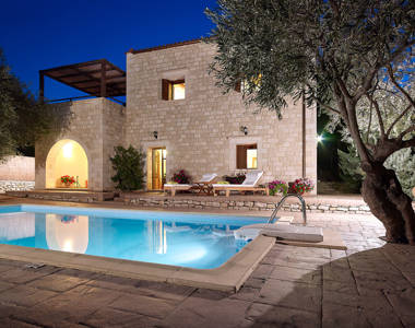 Vederi Estate Villa Kyveli pool and villa exterior lit up at dusk