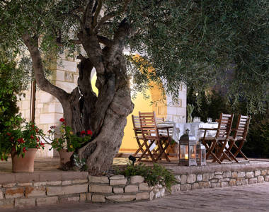 Vederi Estate Villa Kalypso terrace with a big olive tree and the big round table on the side