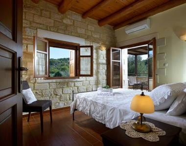 Vederi Estate Villa Kyveli bedroom with double bed, a chair, a bedside table, amenities and balcony view