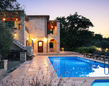 Vederi Estate Villa Melpomeni exterior and pool lit up at dusk