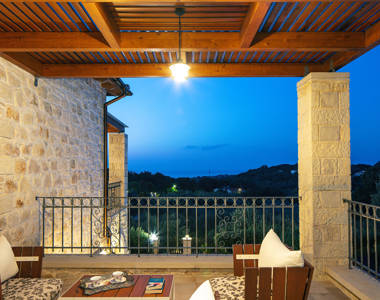 Vederi Estate Villa Melpomeni view from the lit up balcony at dusk