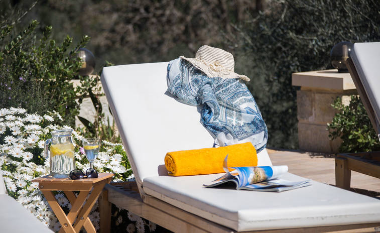 Vederi Estate Villa Melpomeni decorated sunbed and a jug with a glass of water on the table next to the sunbed